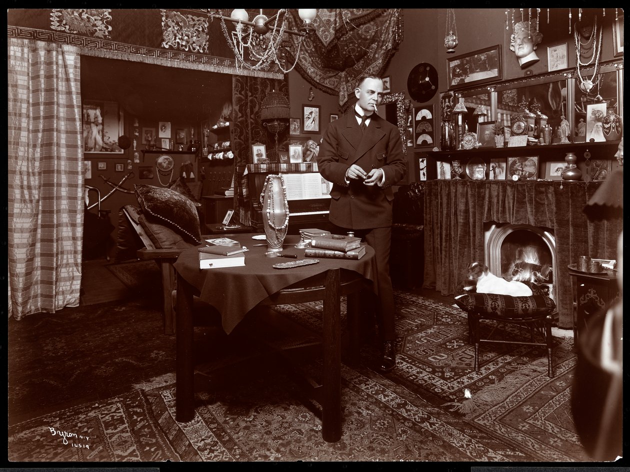 Will R. Barnes står ved et bord i studioet sitt, 1903 (sølv gelatintrykk) av Byron Company