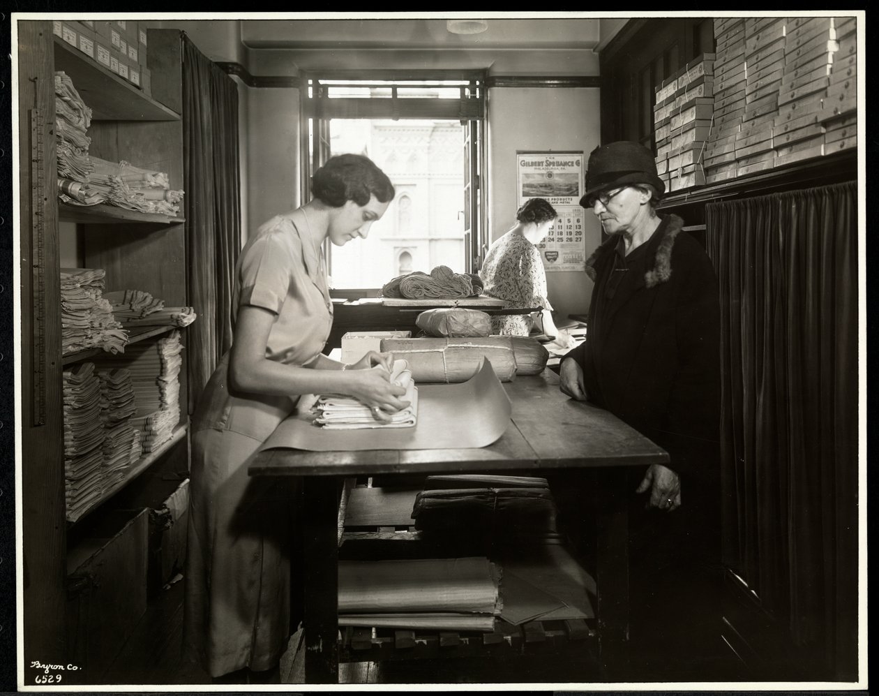 Ung kvinne pakker inn tøymateriale som en hjemmearbeider kan ta med seg, ved New York Association for the Blind, 111 East 59th Street, New York, 1931 (sølv gelatintrykk) av Byron Company