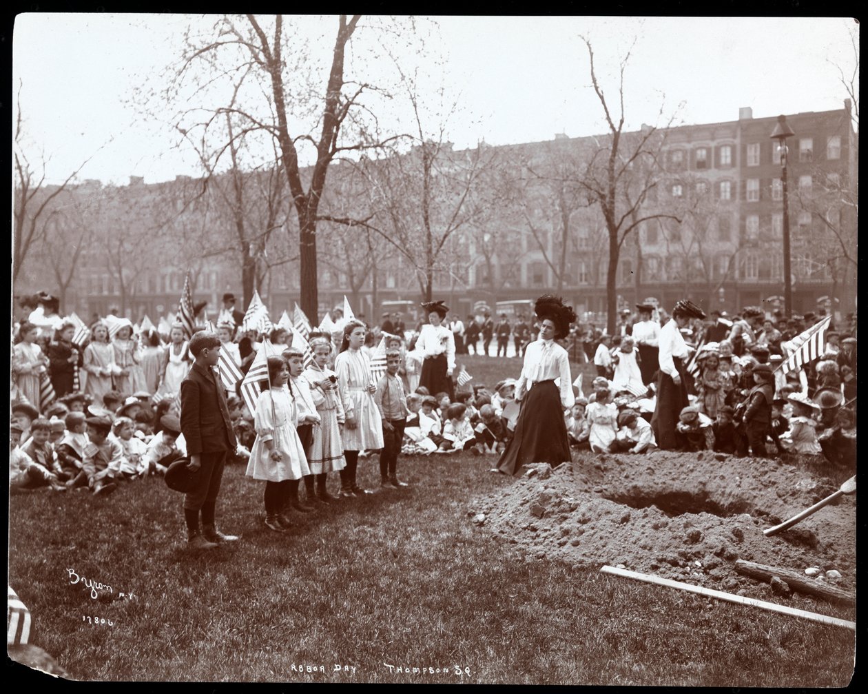Voksne og barn holder flagg stående rundt et nygravd hull for et treplanting på Arbor Day i Tompkins Square Park, New York, 1904 (sølv gelatintrykk) av Byron Company