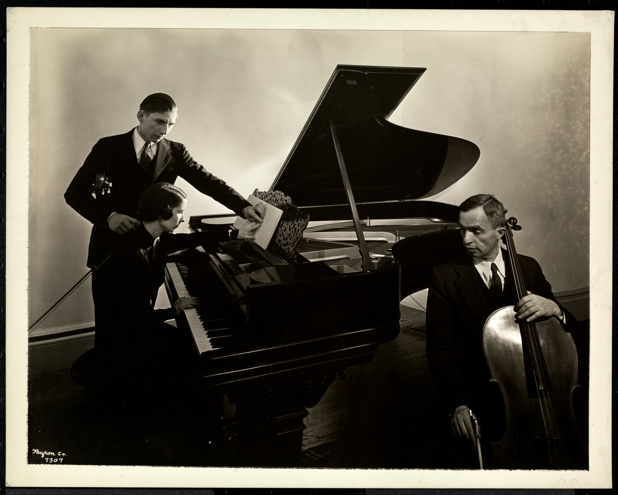 Blind kvinne, Miss Harding, ved pianoet og instruerte to blinde menn på fiolin og cello, 1936 (sølv gelatintrykk) av Byron Company