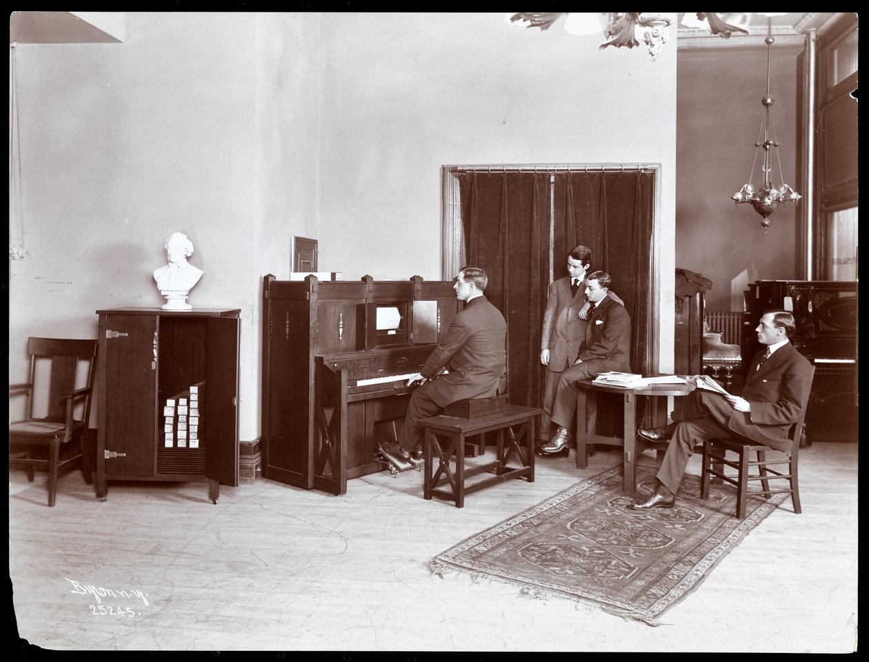 Fire menn, en spiller et piano fra H. Bruman Co., 1907 (sølv gelatintrykk) av Byron Company