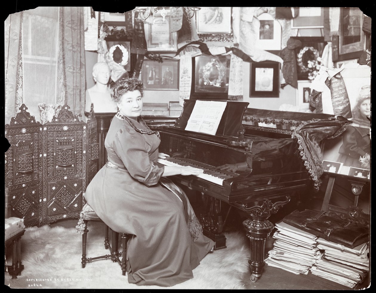 Madame Schumann Heink sittende ved et piano, 1906 (sølv gelatintrykk) av Byron Company