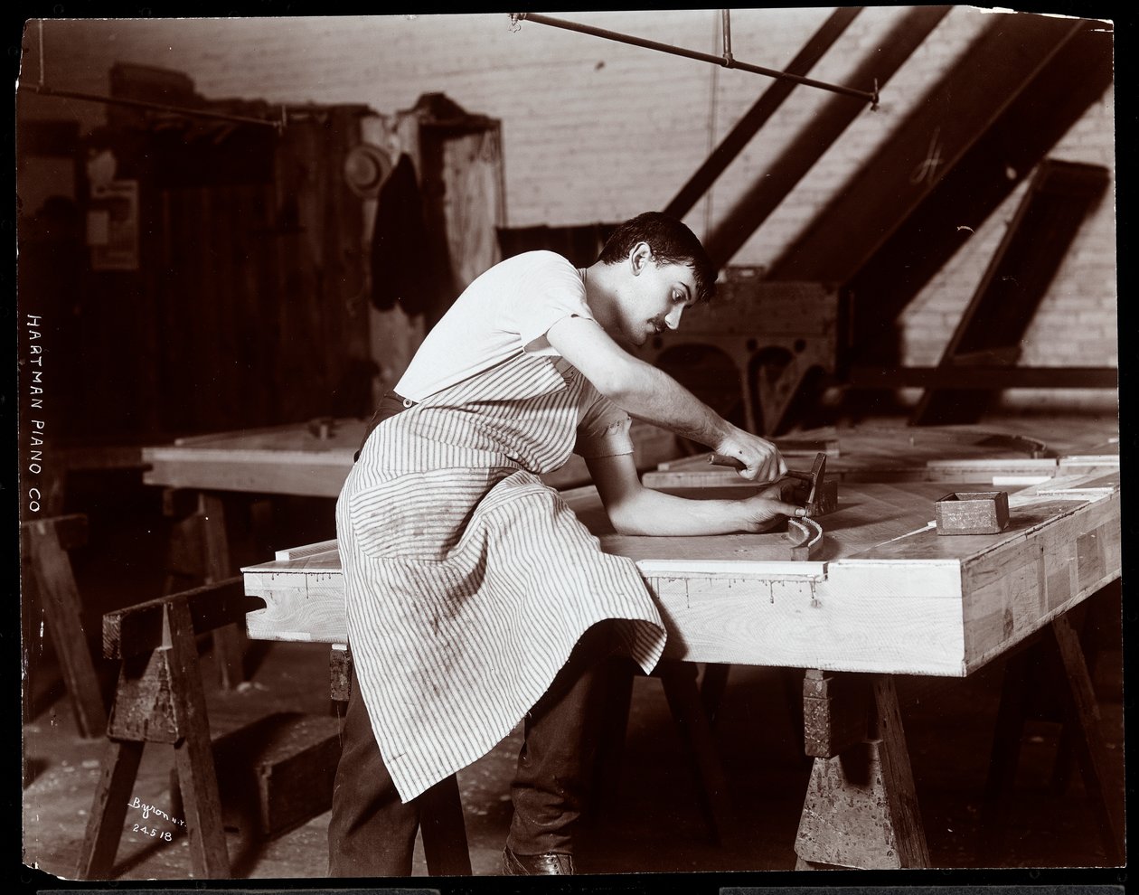 Mann som arbeider i Hardman, Peck und Co. pianofabrikk, New York, 1907 (sølv gelatintrykk) av Byron Company