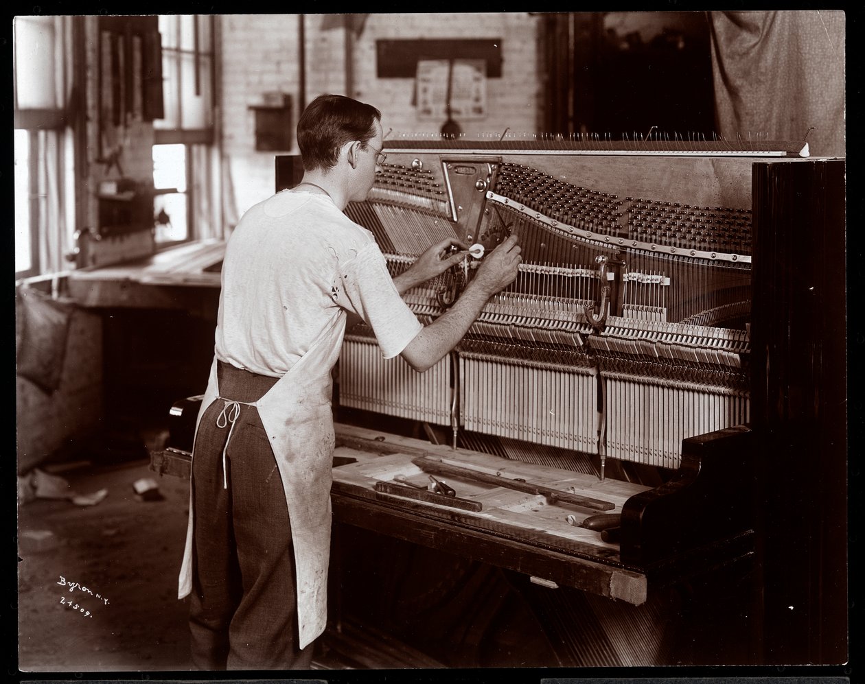 Mann som arbeider i Hardman, Peck und Co. pianofabrikk, New York, 1907 (sølv gelatintrykk) av Byron Company