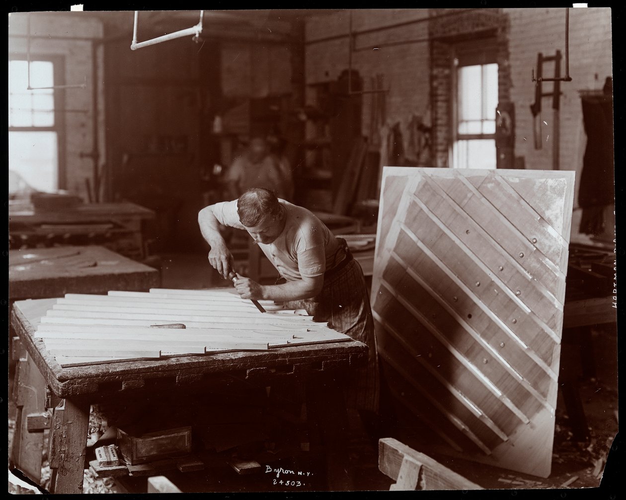 Mann som arbeider i Hardman, Peck und Co. pianofabrikk, New York, 1907 (sølv gelatintrykk) av Byron Company