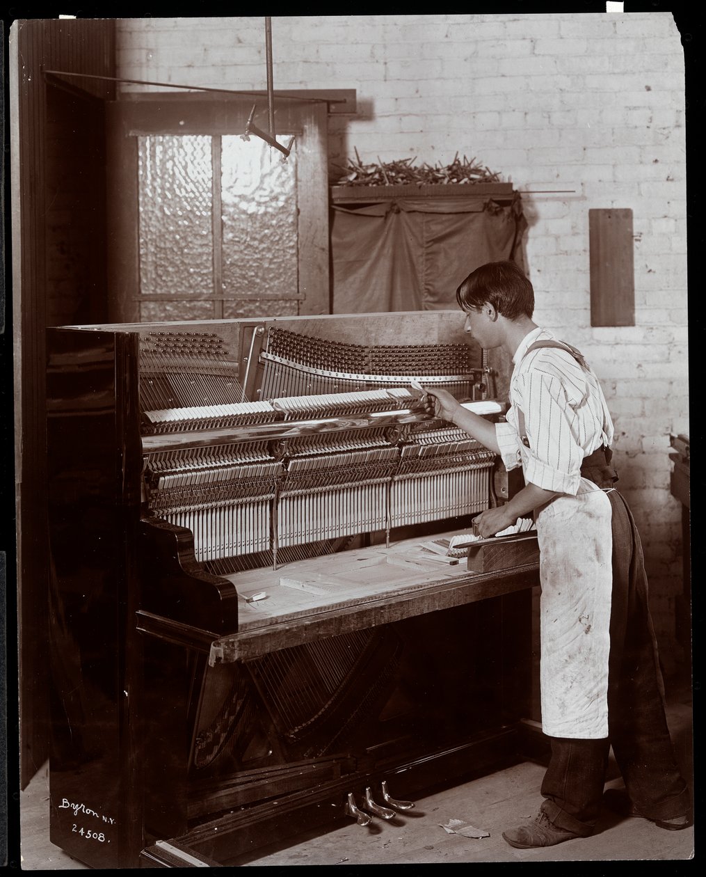 Mann som arbeider i Hardman, Peck und Co. pianofabrikk, New York, 1907 (sølv gelatintrykk) av Byron Company