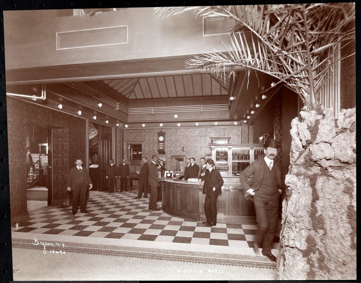 Lobbyen og registreringsskranken på Hotel Victoria, 1900 eller 1901 (sølv gelatintrykk) av Byron Company