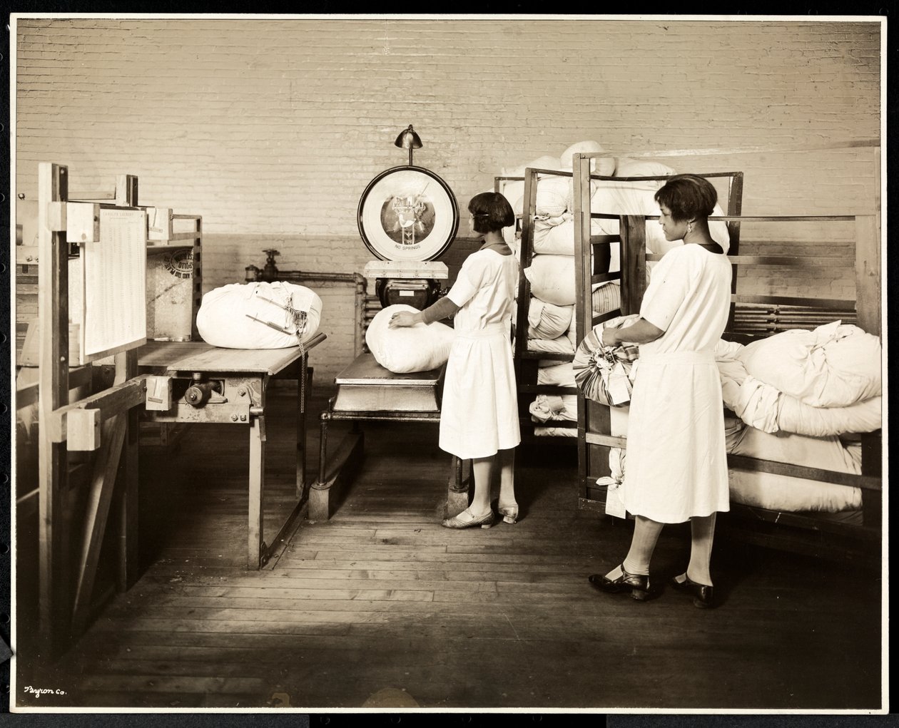To afroamerikanske kvinner som veier poser med klesvask på Carolyn Laundry på 111 East 128th Street, East Harlem, New York, 1928 (sølv gelatintrykk) av Byron Company