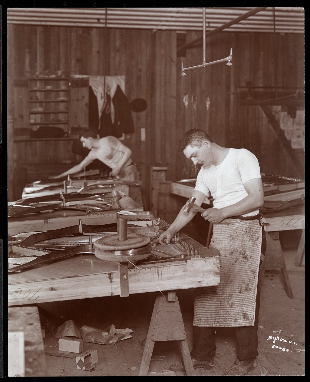 To menn arbeider i Harrington Piano Co.-fabrikken, 1907 (sølv gelatintrykk) av Byron Company
