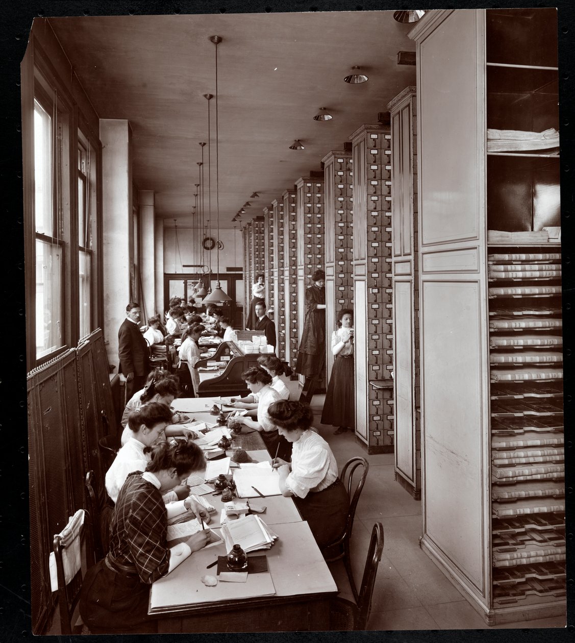 Kvinner som arbeider i et arkivrom, under mannlig tilsyn, ved Metropolitan Life Insurance Co. på 23rd Street og Madison Avenue, New York, 1907 (sølv gelatintrykk) av Byron Company