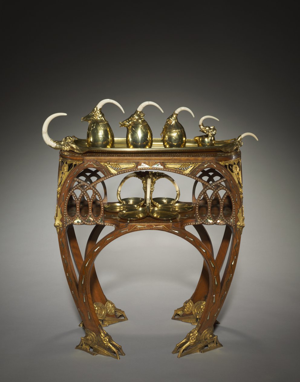 Skuff med fløtekanne, dekket sukkerskål, tekanne, varmtvannsgryte og salver, utført av Adrien-Aurélien Hebrard (1866-1937), og bord, ca. 1907 (innlagt tre (mahogni?), støpte og forgylt bronsefester, innlegg av elfenben eller bein, metall og perlemor (mar av Carlo Bugatti