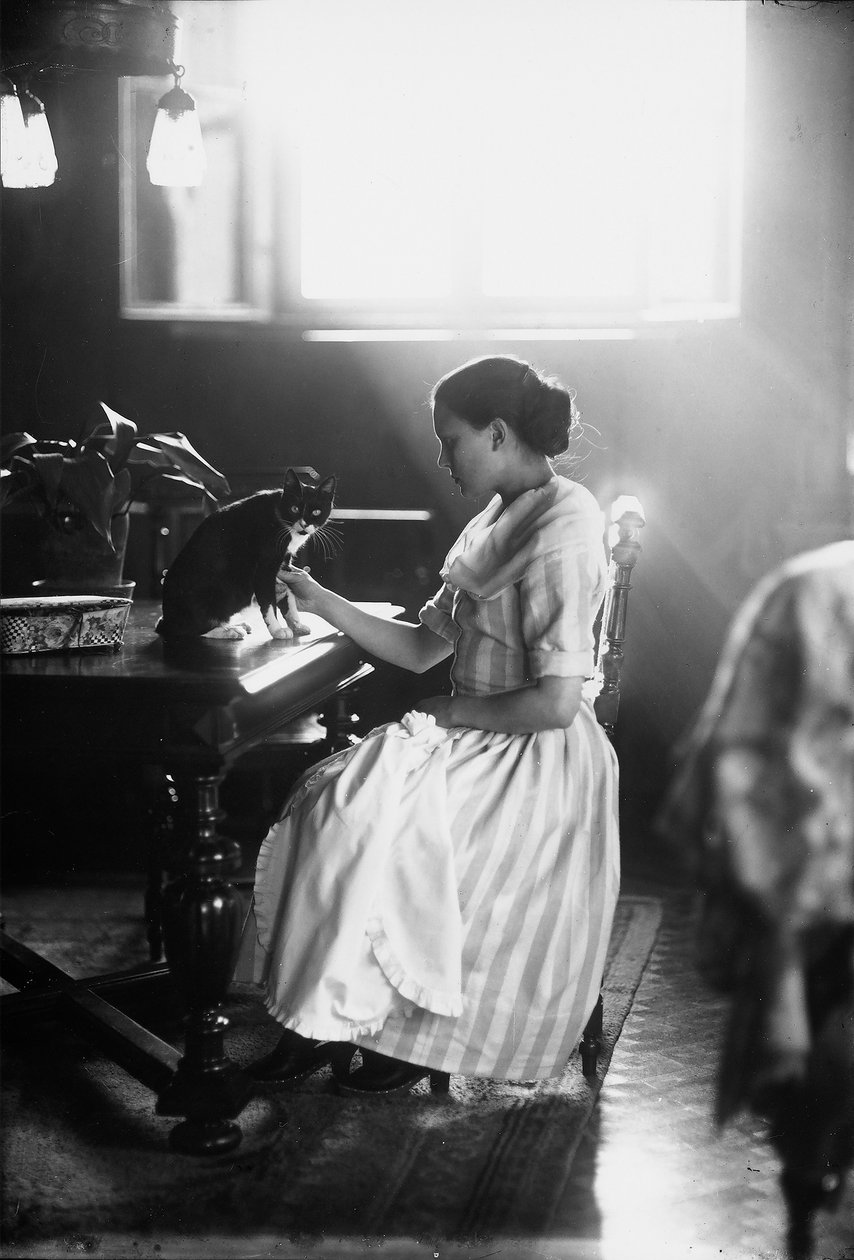 Portrett av Wanda som sitter ved et bord med katten sin, Trieste, ca. 1910 (glassplate) av Carlo Wulz