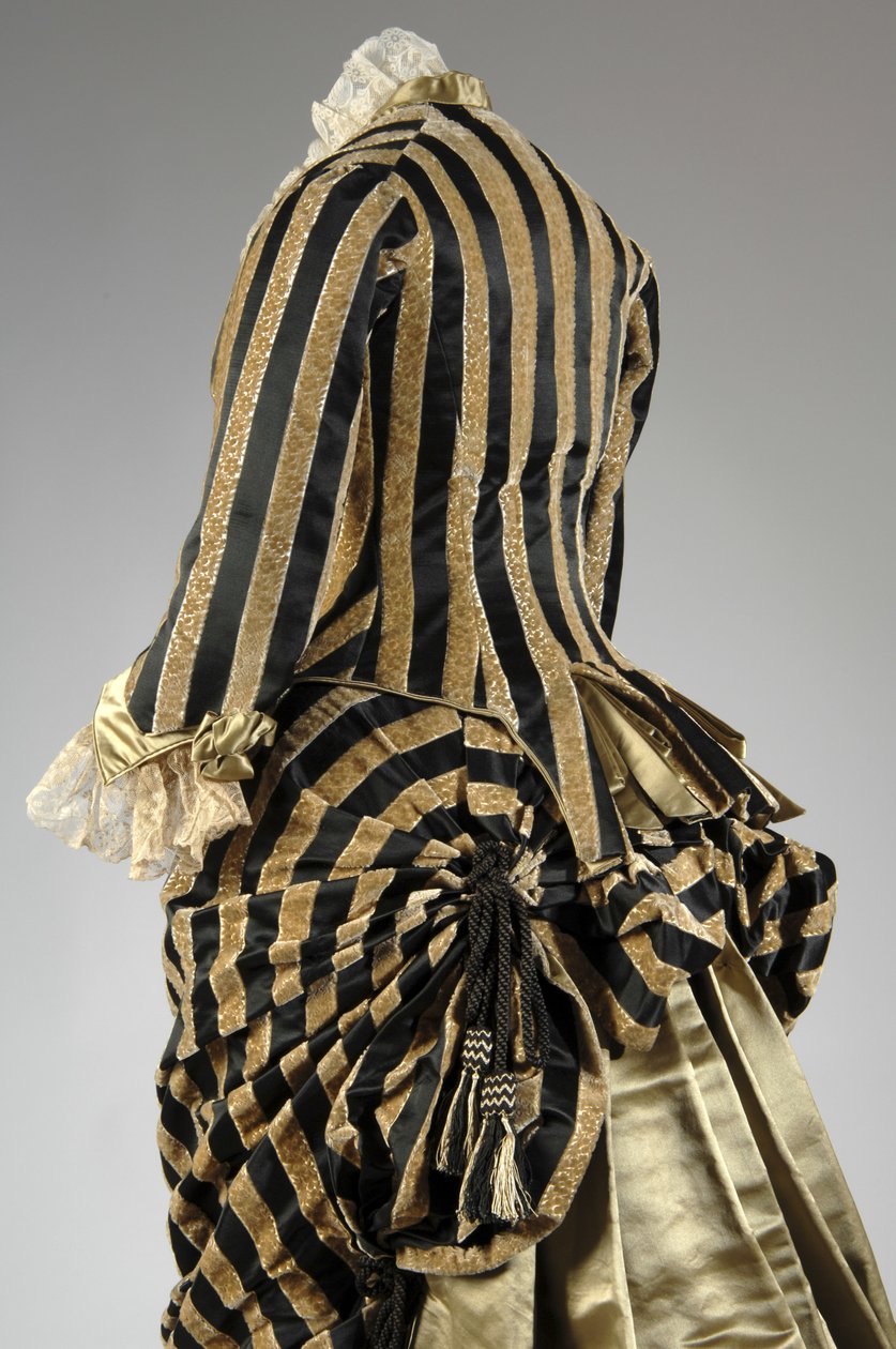 Aftenkjole, ca. 1884 (skrå delvis rygg). Silkesateng og kuttet fløyel, blonder, silketråddusker og frynser. Charles Frederick Worth, Frankrike. av Charles Frederick Worth