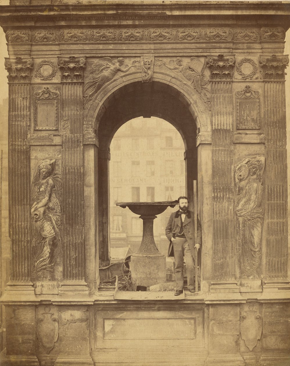 [Uidentifisert mann poserer i Fontaine des Innocents] av Charles Marville