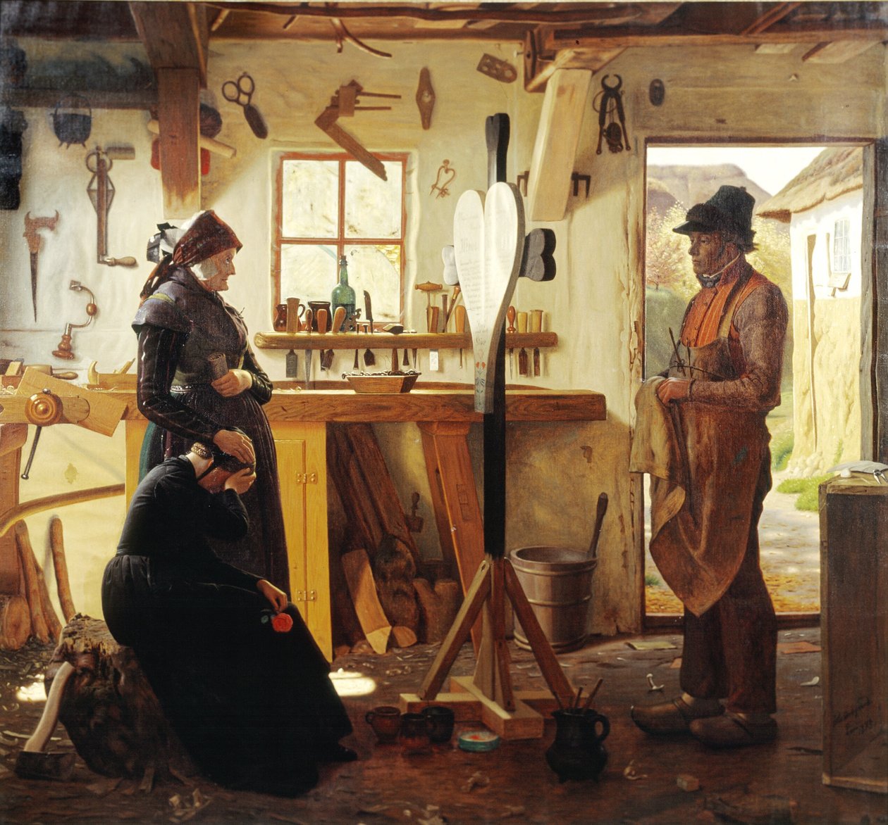 To kvinner besøker landsbykunstneren for å se det bestilte gravkorset av Christen Dalsgaard