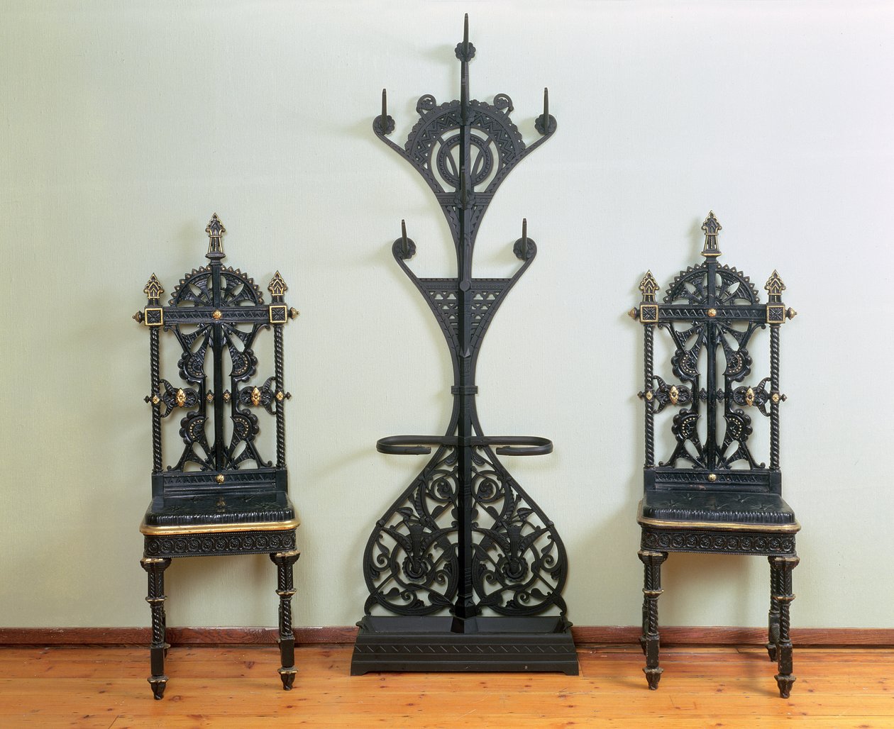 Frakk-, hatte- og paraplystativ flankert av to hage- eller hallstoler, Coalbrookdale, 1867-69 (støpejern) av Christopher Dresser