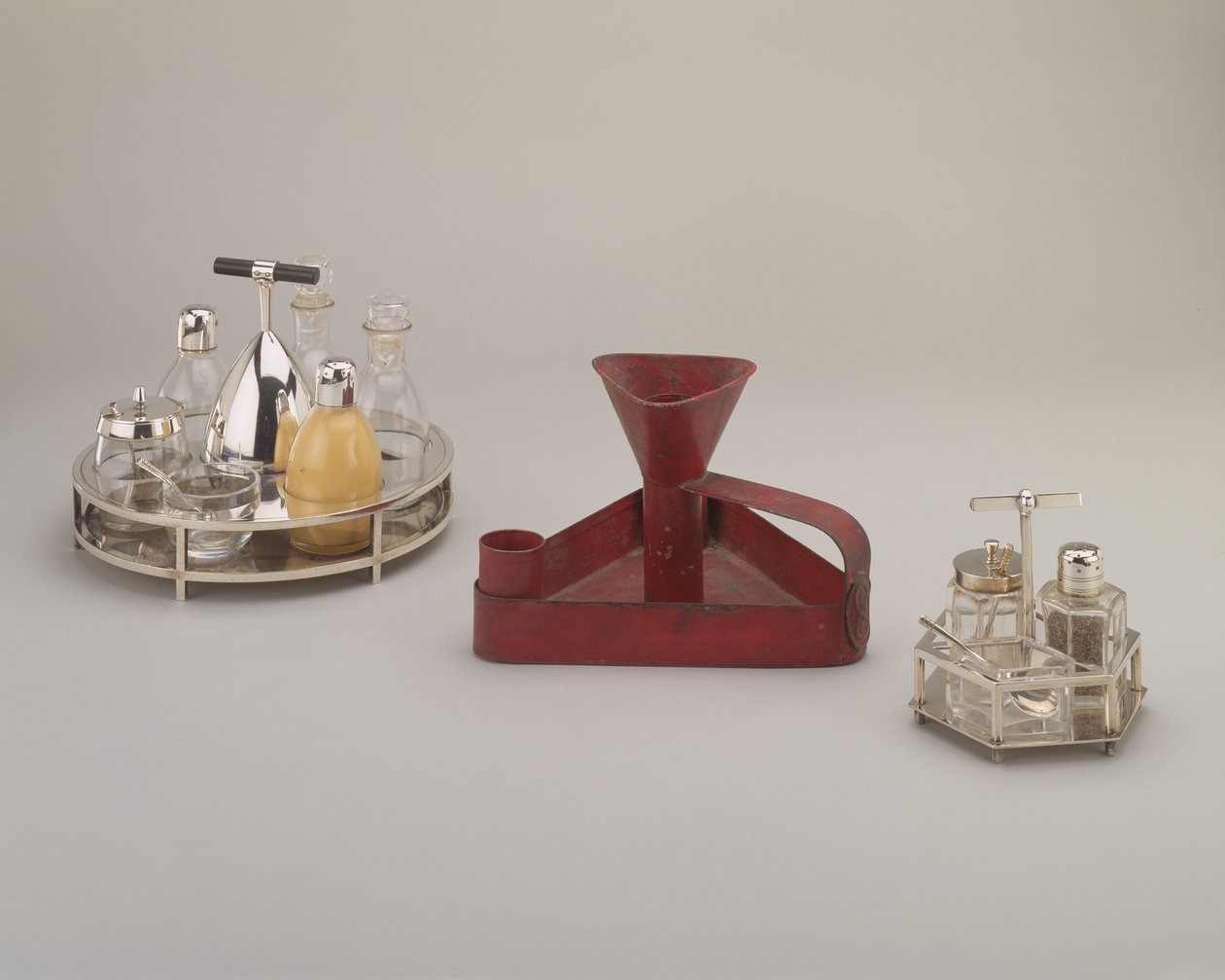 Elektrobelagt sølv cruet sett, Elkington & Co., 1885; rød trekantet drypppanne i hermetisk jern, Richard Perry, Son & Co., ca. 1876; galvanisert sølv cruet sett, Hukin & Heath, 1885 av Christopher Dresser