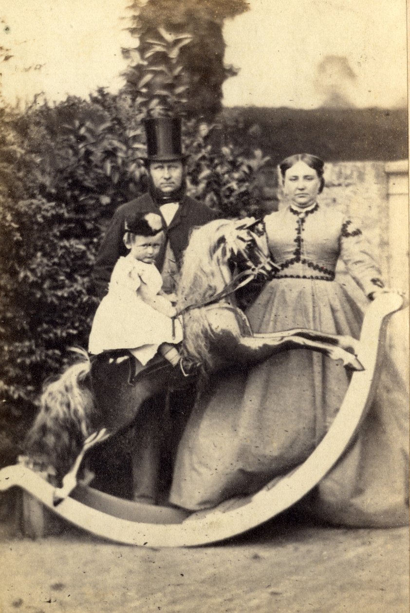 Ung jente på stor gyngehest med mann og kvinne stående, 1860-tallet (albumintrykk) av Cruttenden