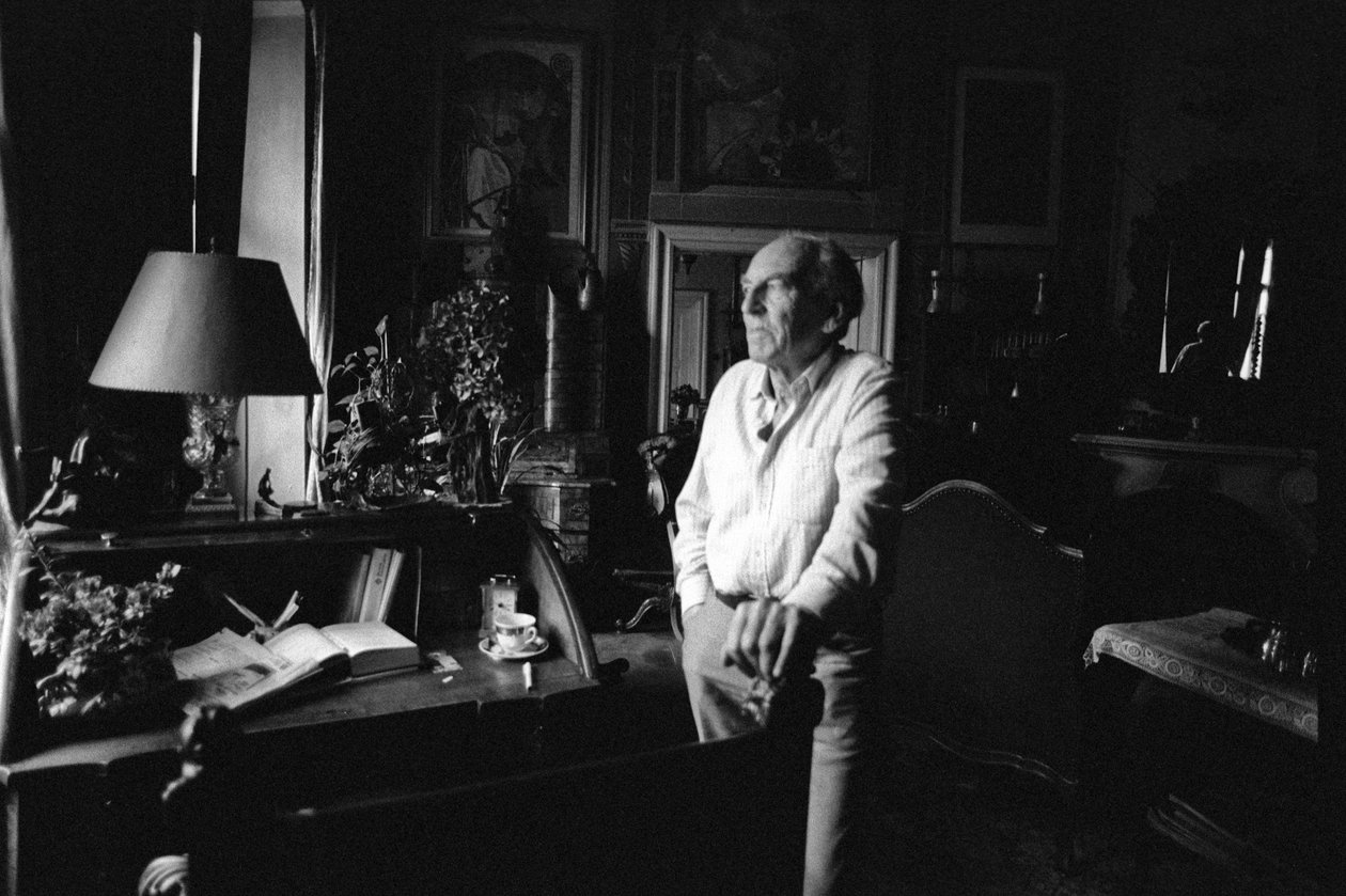 Jiri Mucha står ved skrivebordet sitt i huset sitt i Hradcany, Praha av Czech Photographer