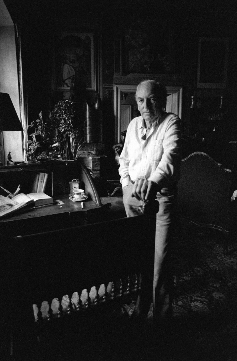 Jiri Mucha står ved skrivebordet sitt i huset sitt i Hradcany, Praha av Czech Photographer
