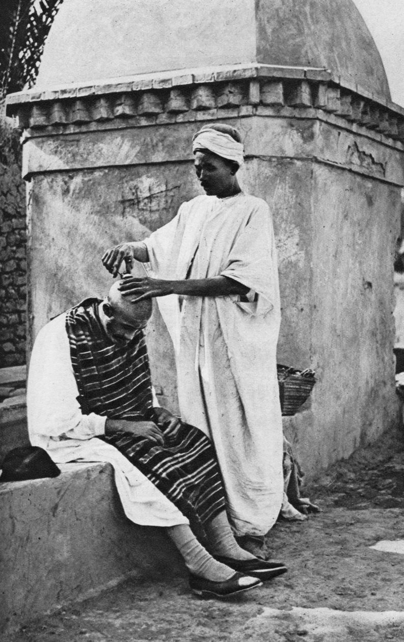 En gatefrisør og hans klient, Algerie, Afrika, 1922. av Donald McLeish