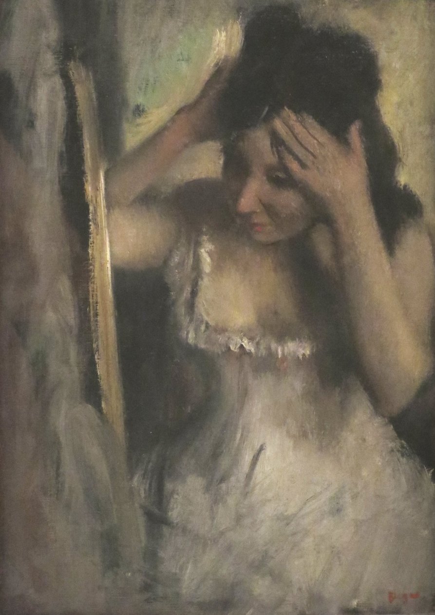Kvinne som gre håret foran et speil av Edgar Degas