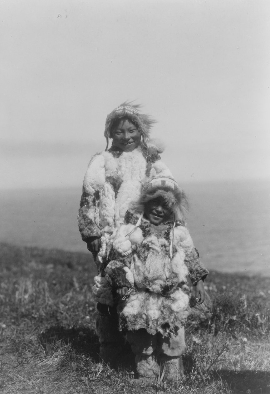 Et lite barn og en eldre eskimo iført parkas med andeskinn, Nunivak Island, Alaska, ca. 1929 (s/hvitt-bilde) av Edward Sheriff Curtis