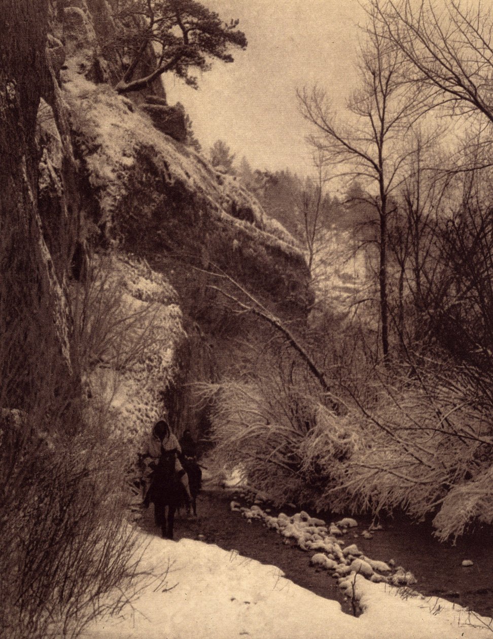Passerer klippen, vinterscenen. Apsaroke-indianere som rir langs en klippe i snøen på Pryor River, Montana. Foto hentet fra bind 4 av leksikonet utgitt av Edward S. Curtis (1868-1952) om indianerne i Nord-Amerika, med et forord av Theo av Edward Sheriff Curtis