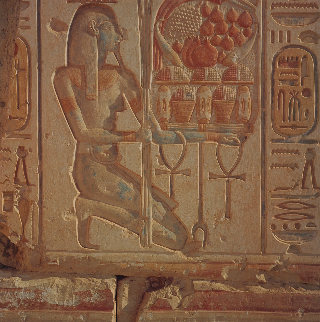 Knælende figur som presenterer kurver med mat, fra Temple of Ramesses II, New Kingdom, ca. 1304-1270 f.Kr. (malt sandsteinsrelieff) av Egyptian 19th Dynasty