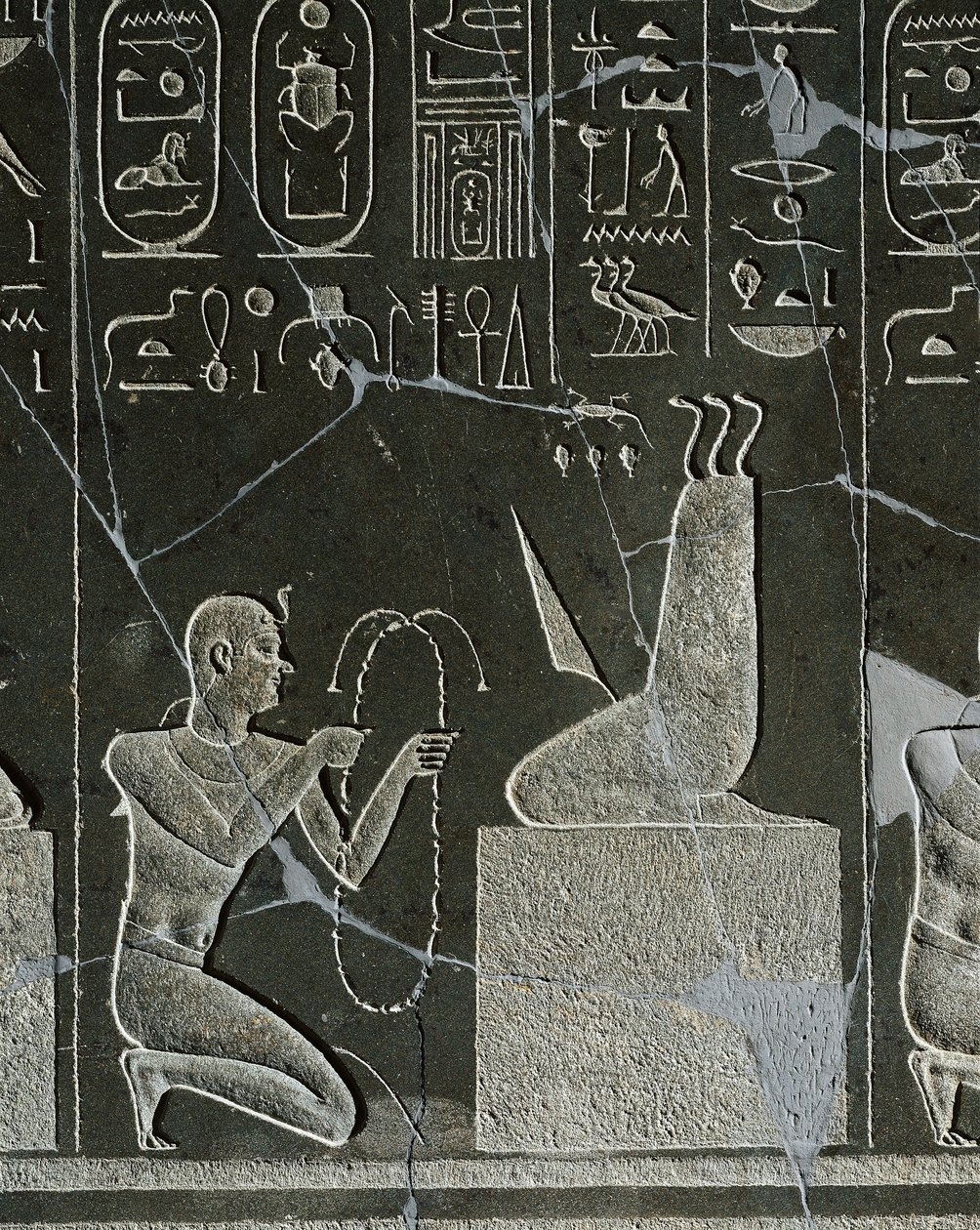 Doleritt-relieff av Nectanebo I, konge som tilbyr halskjede til demonen, representert av knivblad og tre slanger, fra Heliopolis ved Atum-tempelet av Egyptian 30th Dynasty