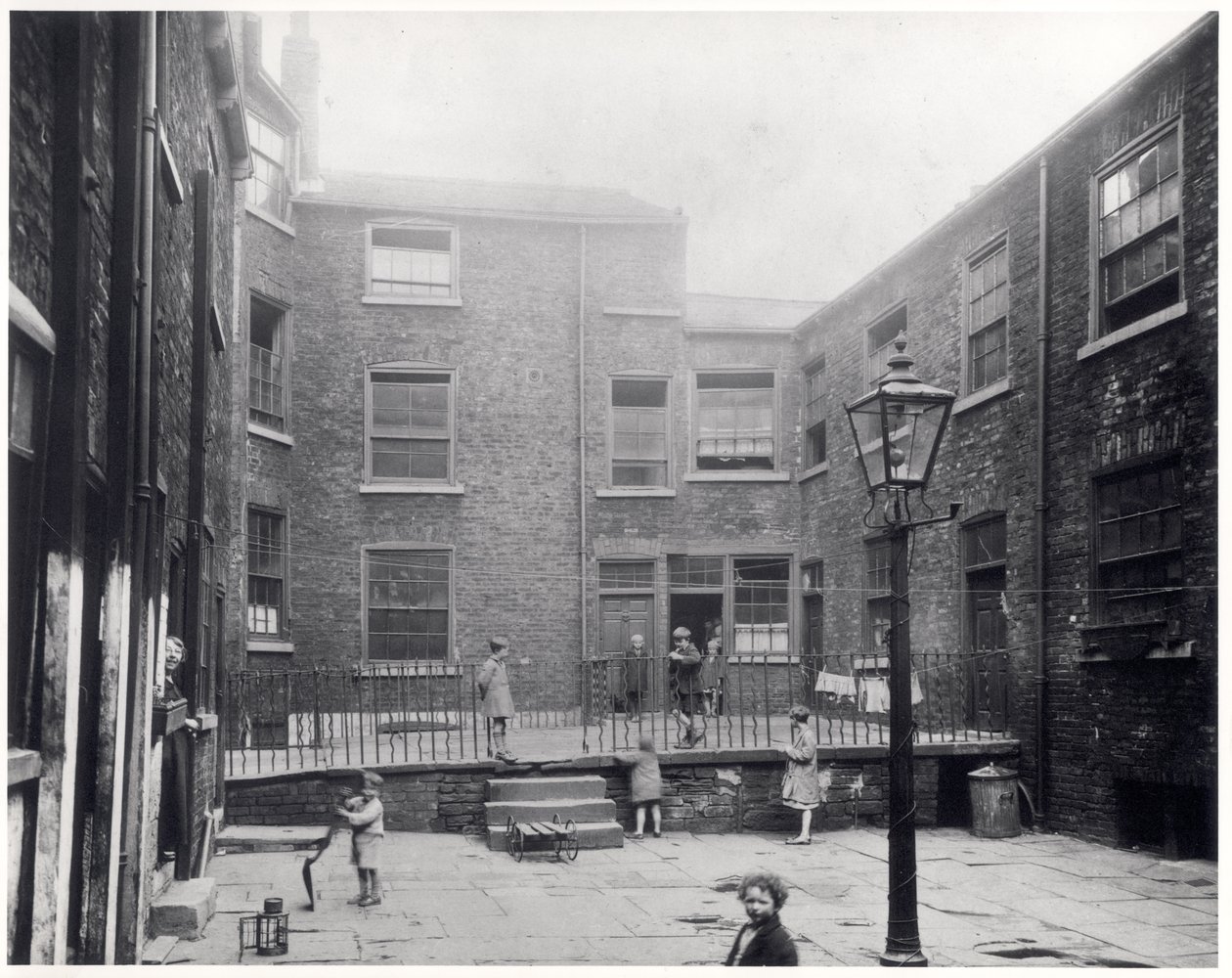 Barn som leker på Hirst Square, Leeds, før det ble revet for å gjøre plass til den nye Civic Hall, 29. juli 1930 av English Photographer