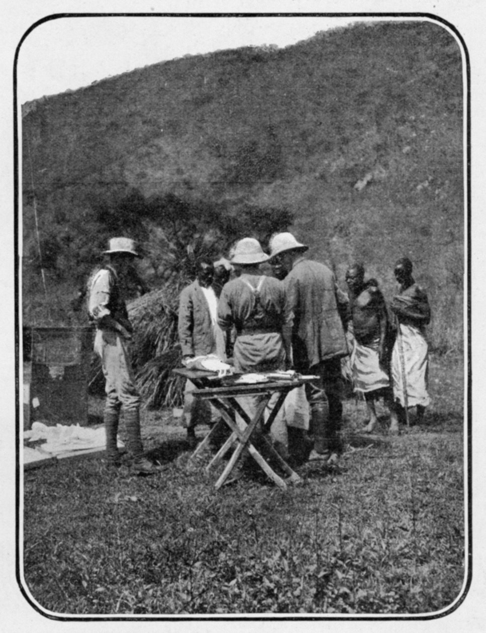 Discusing the Situation: a Conference in Camp, fra en artikkel med tittelen To the Mountains of the Moon publisert i The Graphic 27. oktober 1906 av English Photographer