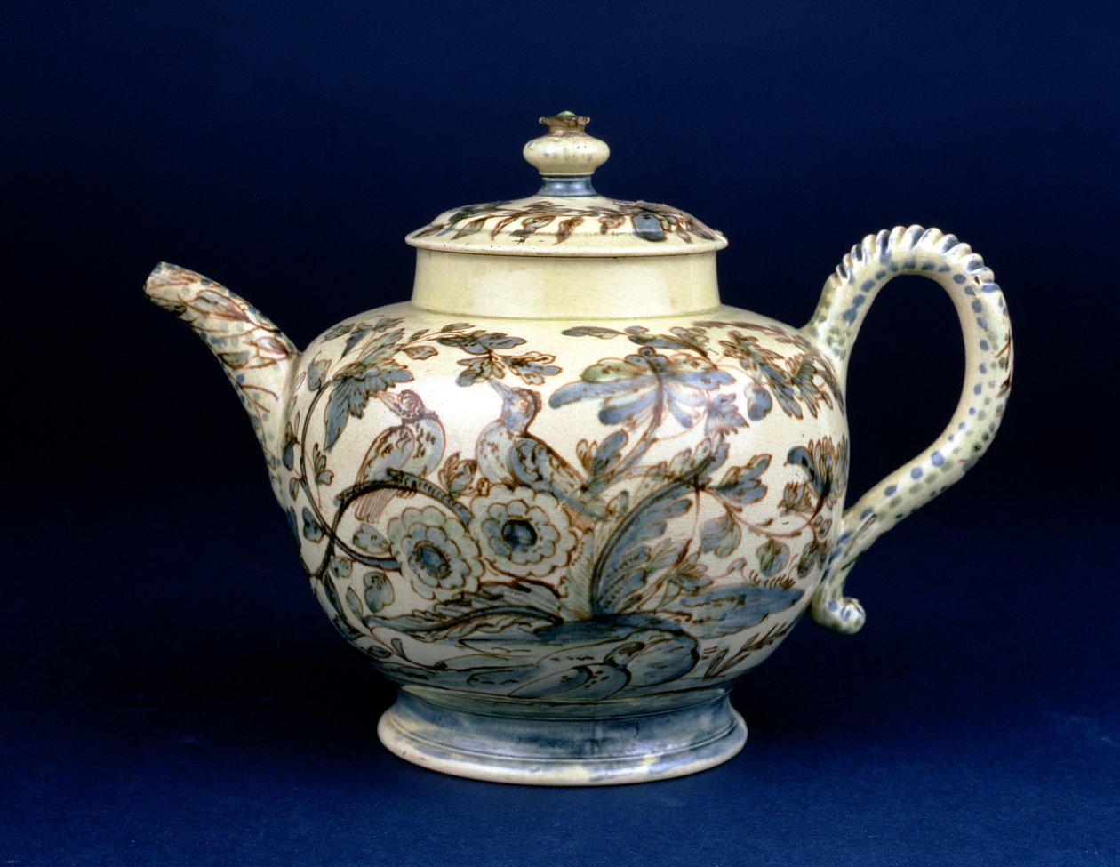Staffordshire Creamware tekanne kjent som The Tunstall Teapot dekorert med tre fugler i orientalsk løvverk, malt i brunaktig mangan konturene forsterket i blå og grønn underglasur av F. Morg av English School