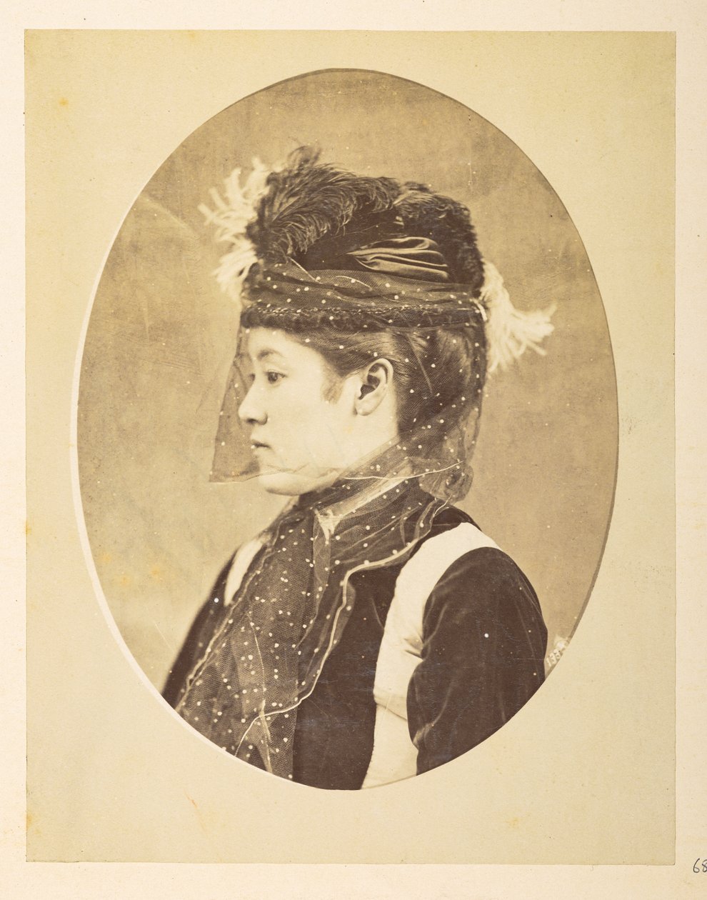 Japansk kvinne i europeisk kjole, Ovalt bilde; hode-og-skuldre venstre profilportrett av en ung japansk kvinne i europeisk kjole, med hatt og slør,     Fotograf: Ukjent  Lucas Collection: Fotografisk oversikt over verdensturneen til Charles James og av English Photographer