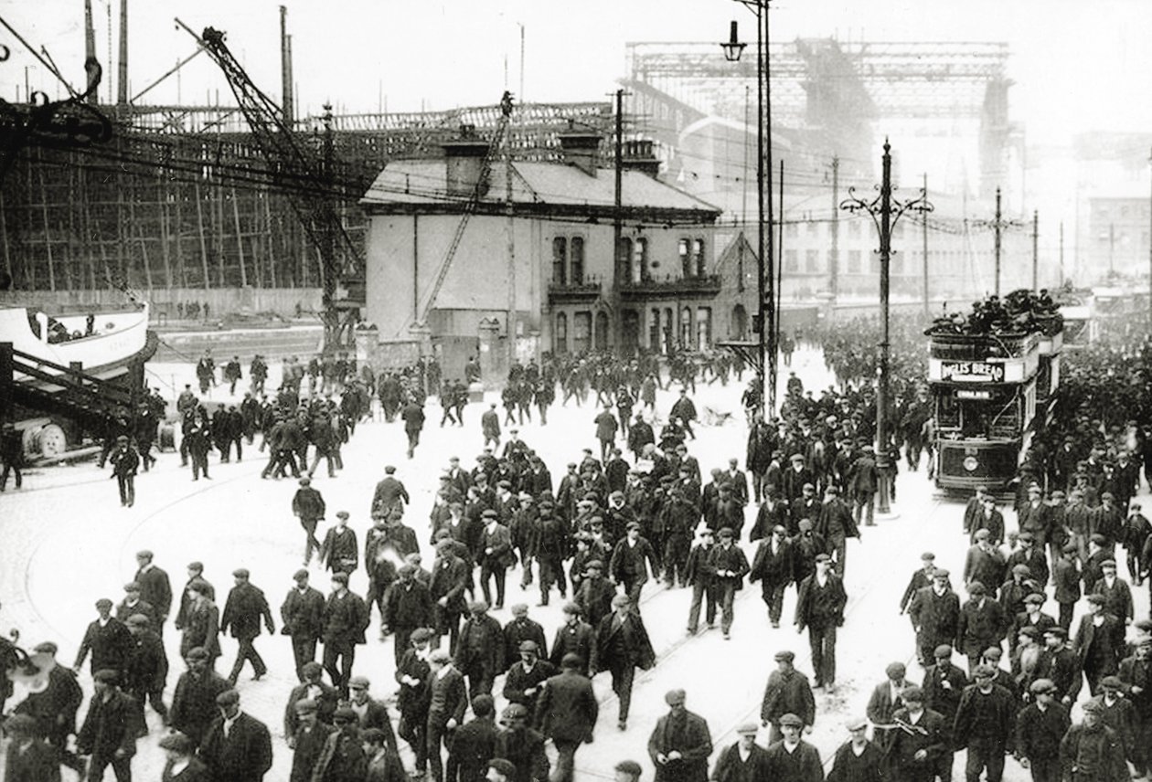 Avslutningstid ved Harland und Wolff-verftet, Belfast, Irland med Titanic under bygging i bakgrunnen, 1910-11 av English Photographer