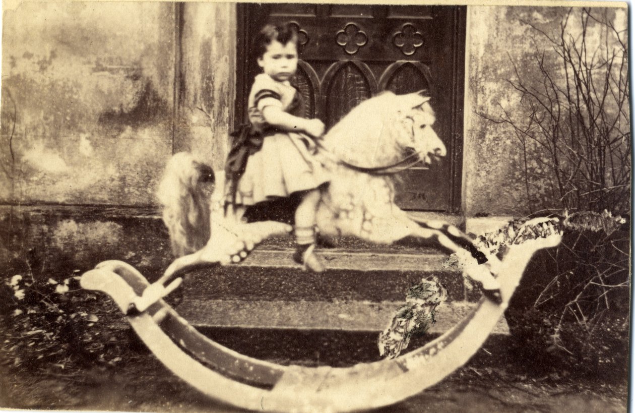 Liten jente på en stor gyngehest i en hage, 1860-tallet (albumintrykk) av English Photographer