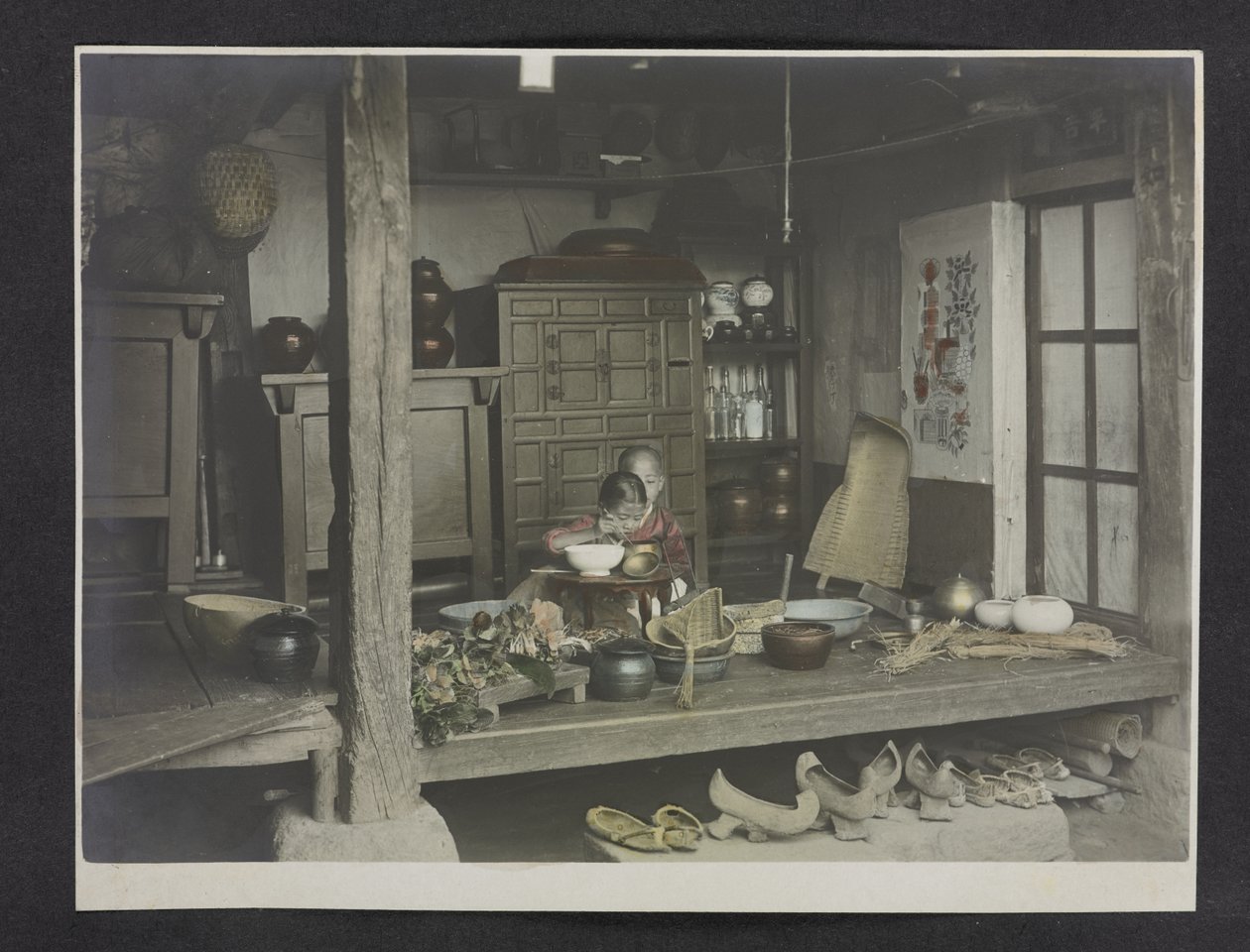 To barn spiser, inne i et hus, fotografialbum av Korea av English Photographer