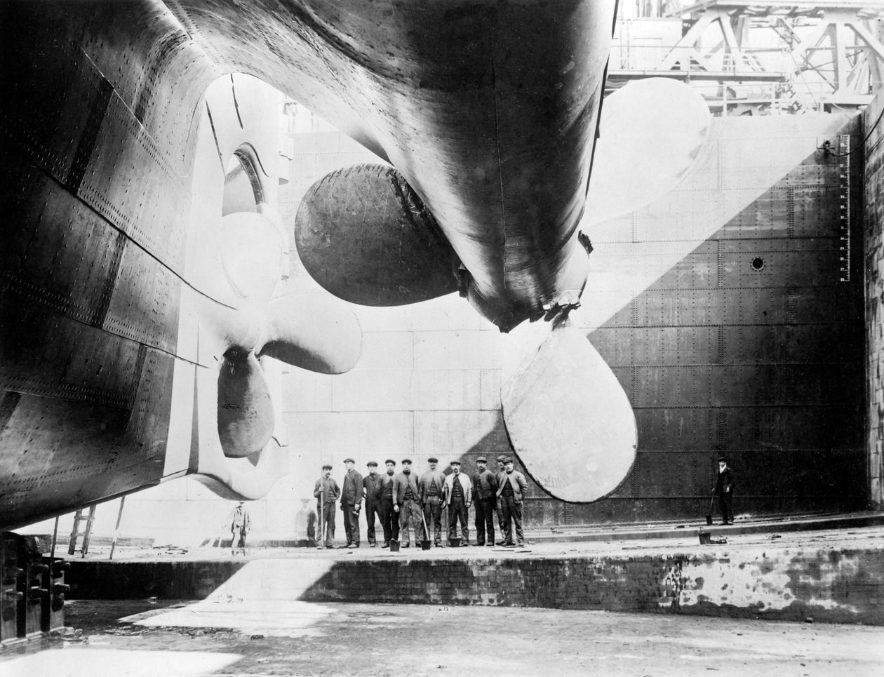Arbeidere som står under en av propellene til Titanic, 31. mai 1911. av English Photographer