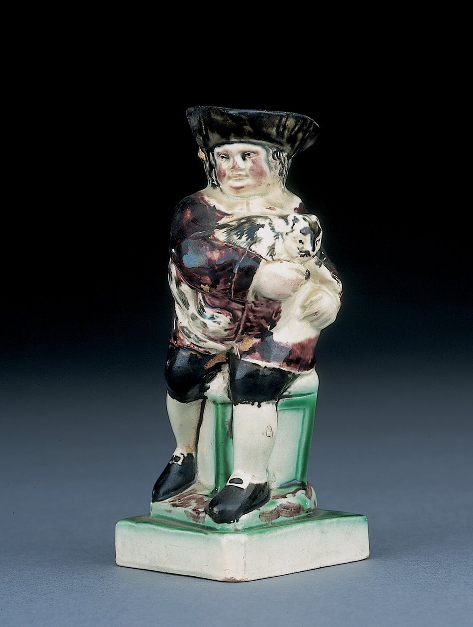Dick Whittington kanne, støpt opp fra en stol med høy rygg, holder katten sin, sprutet i brune, grønne og svarte klær, et støpt skjold ved siden, ca. 1790 av English School