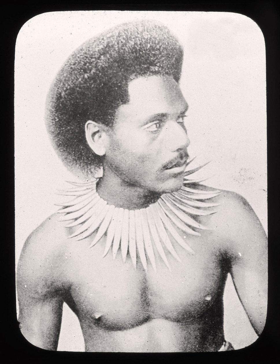 Magisk lyktlysbilde som viser en fijiansk høvding i tradisjonell drakt ca. 1900 av English School