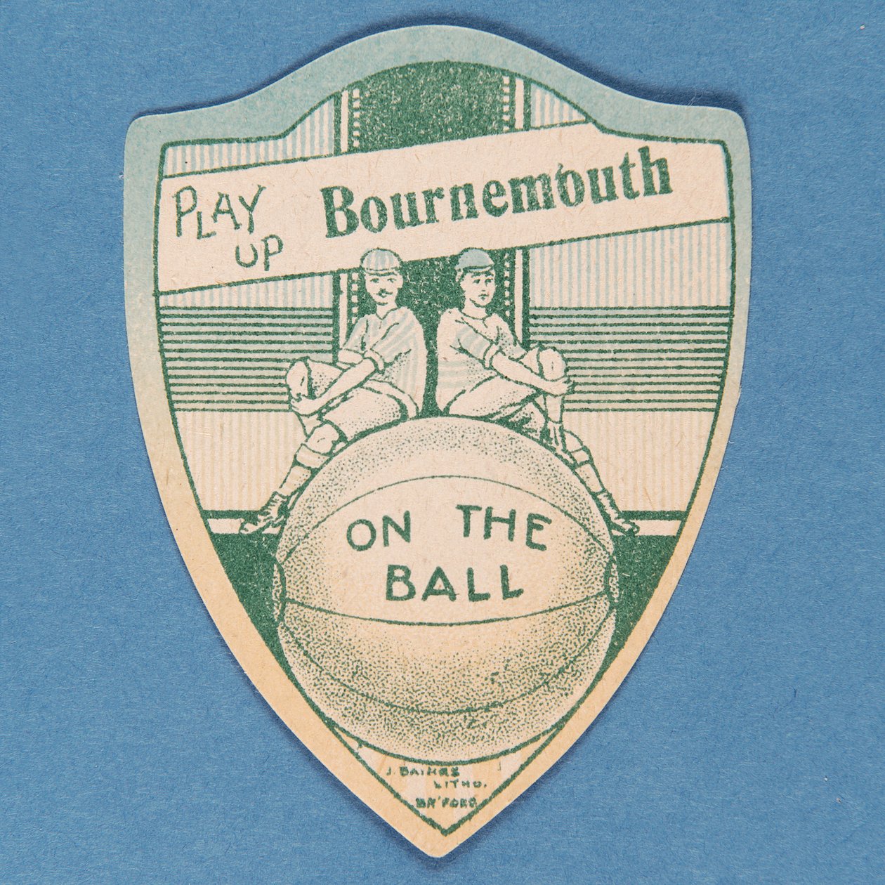 Spill opp Bournemouth, Baines-kort i form av et skjold og to fotballspillere som sitter på toppen av en stor fotball, 1888-89 av English School