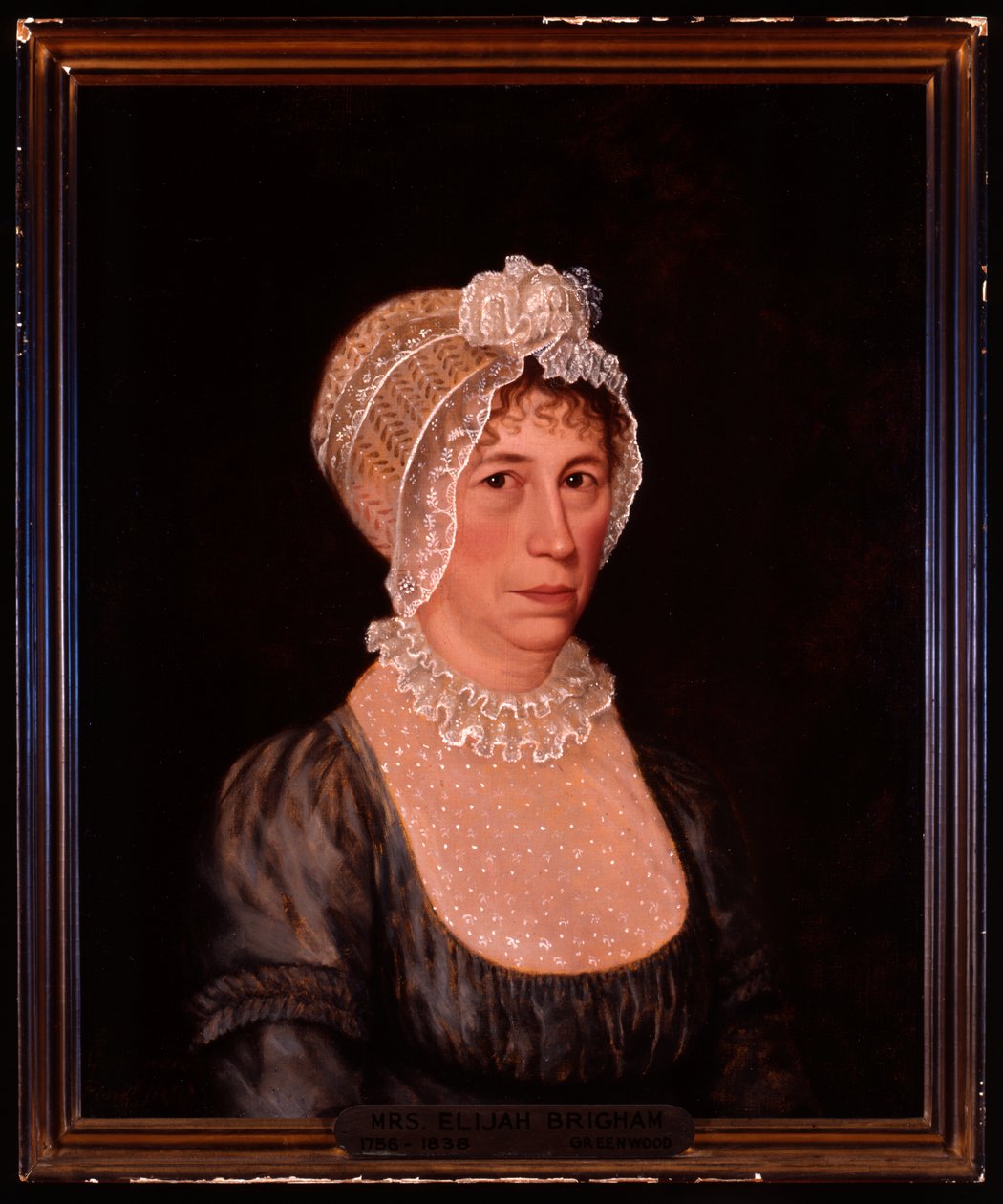 Halvlengde portrett av Sarah Ward Brigham iført en lavt snittkjole med blondedetaljer og blondehette av Ethan Allen Greenwood