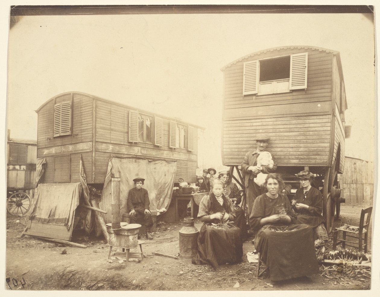[Romfolk sittende utenfor vognene sine] av Eugène Atget