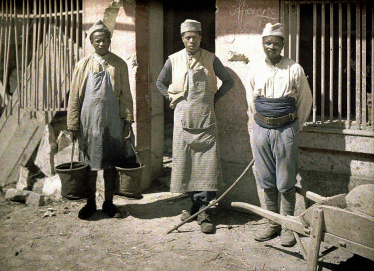 Tre arbeidere fra Senegal foran et hus, Soissons, Aisne, Frankrike, 1917 (autokrom) av Fernand Cuville