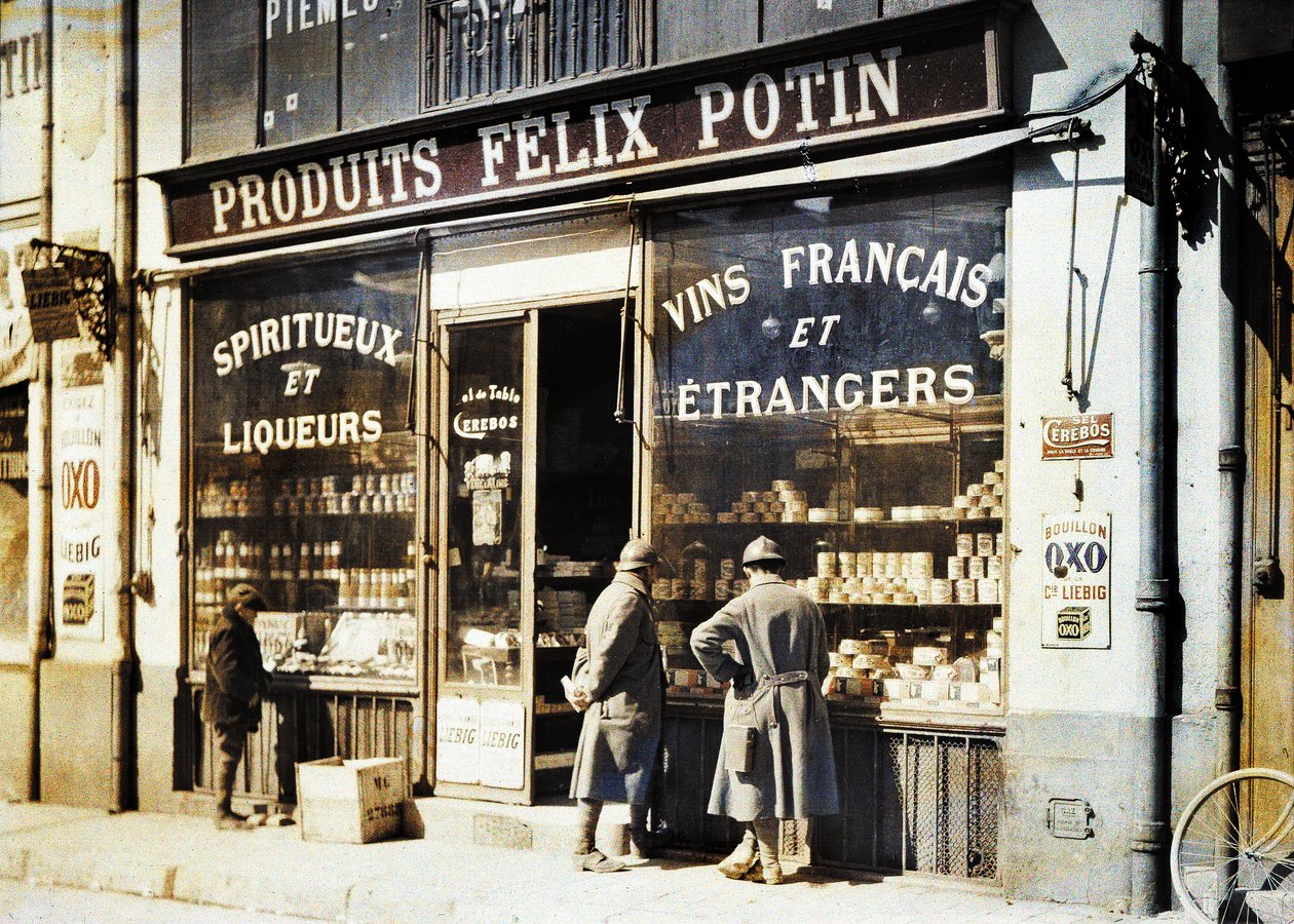 To franske soldater og en gutt foran vinmonopolen Felix Potin på markedet, Reims, Marne, Frankrike, 1917 (autokrom) av Fernand Cuville