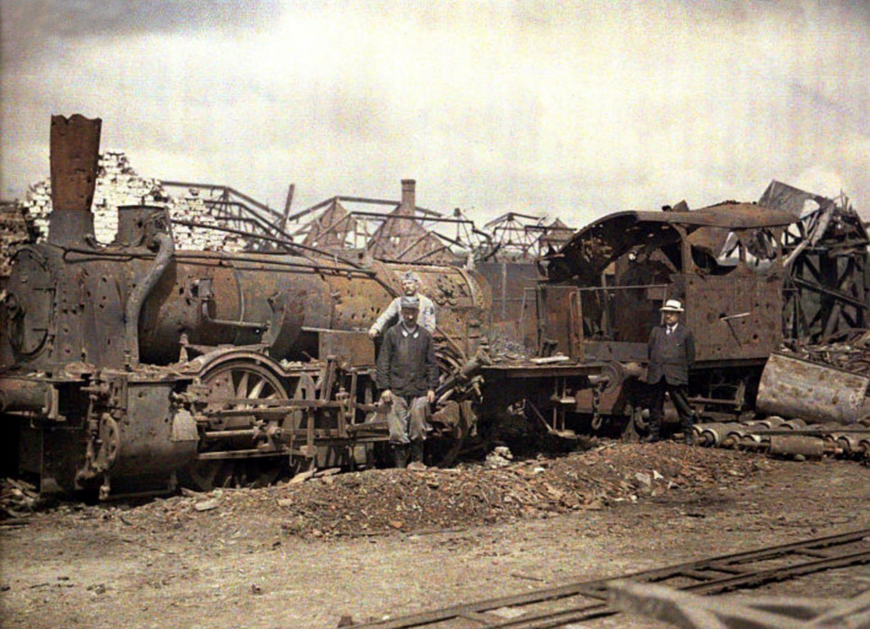 Utbrent lokomotiv og jernbanevogn foran ruinene av det sterkt skadede Vauxrot-destilleriet, Cuffies, Aisne, Frankrike, 1917 (autokrom) av Fernand Cuville
