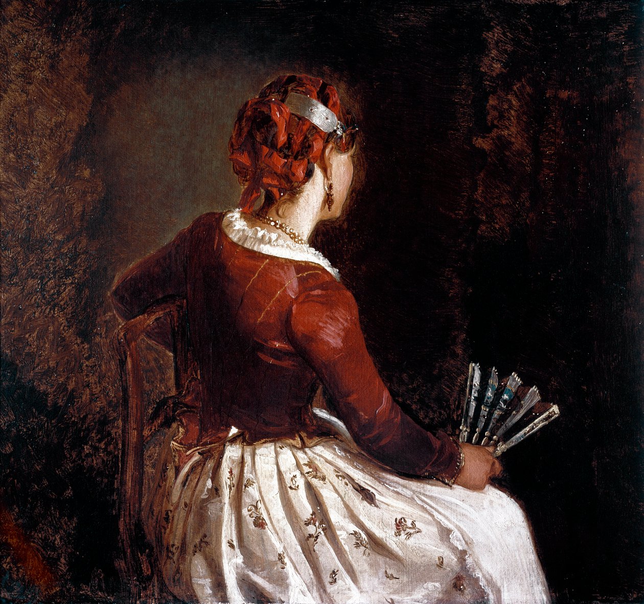 Kvinnen har viften. Portrett av en sittende kvinne vendt tilbake iført et forkle, et skjørt med blomster og røde bånd i håret og en vifte i hånden. Maleri av Filippo Palizzi (1818-99). Roma, Galleria d