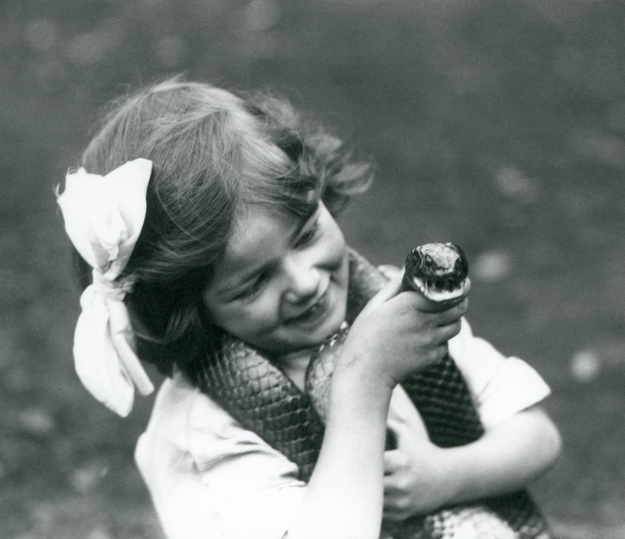 En ung jente Betty som holder en Eastern Indigo Snake, London Zoo, 1924 av Frederick William Bond