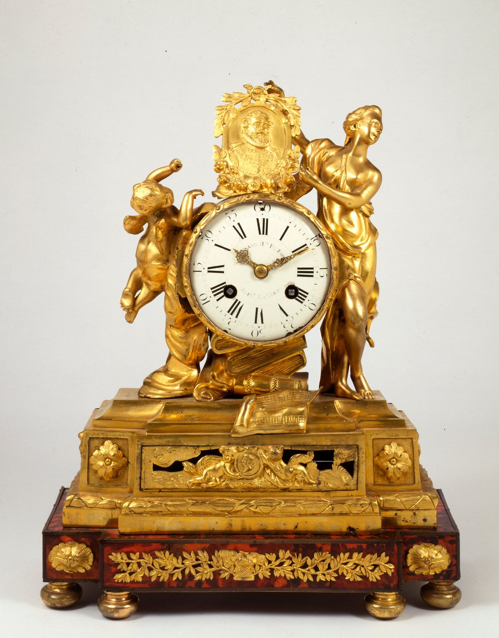 En sen Louis XV ormolu mantelklokke med en profilmedaljong av Henri IV holdt av Venus av French School