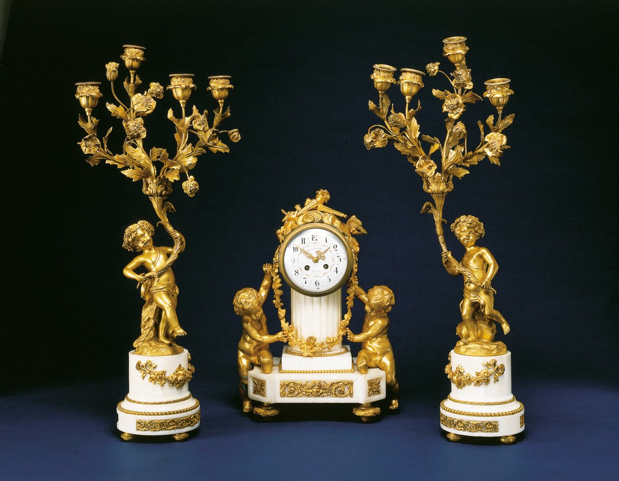 Garniture forhandlet av Black, Starr og Frost bestående av en peisklokke og et par firelyse kandelaber, ca. 1875-1900 av French School